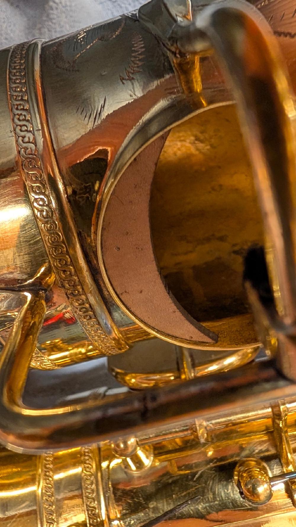 Close-up of a cork tonehole crescent glued into a bell tonehole Close-up of a cork tonehole crescent glued into a bell tonehole